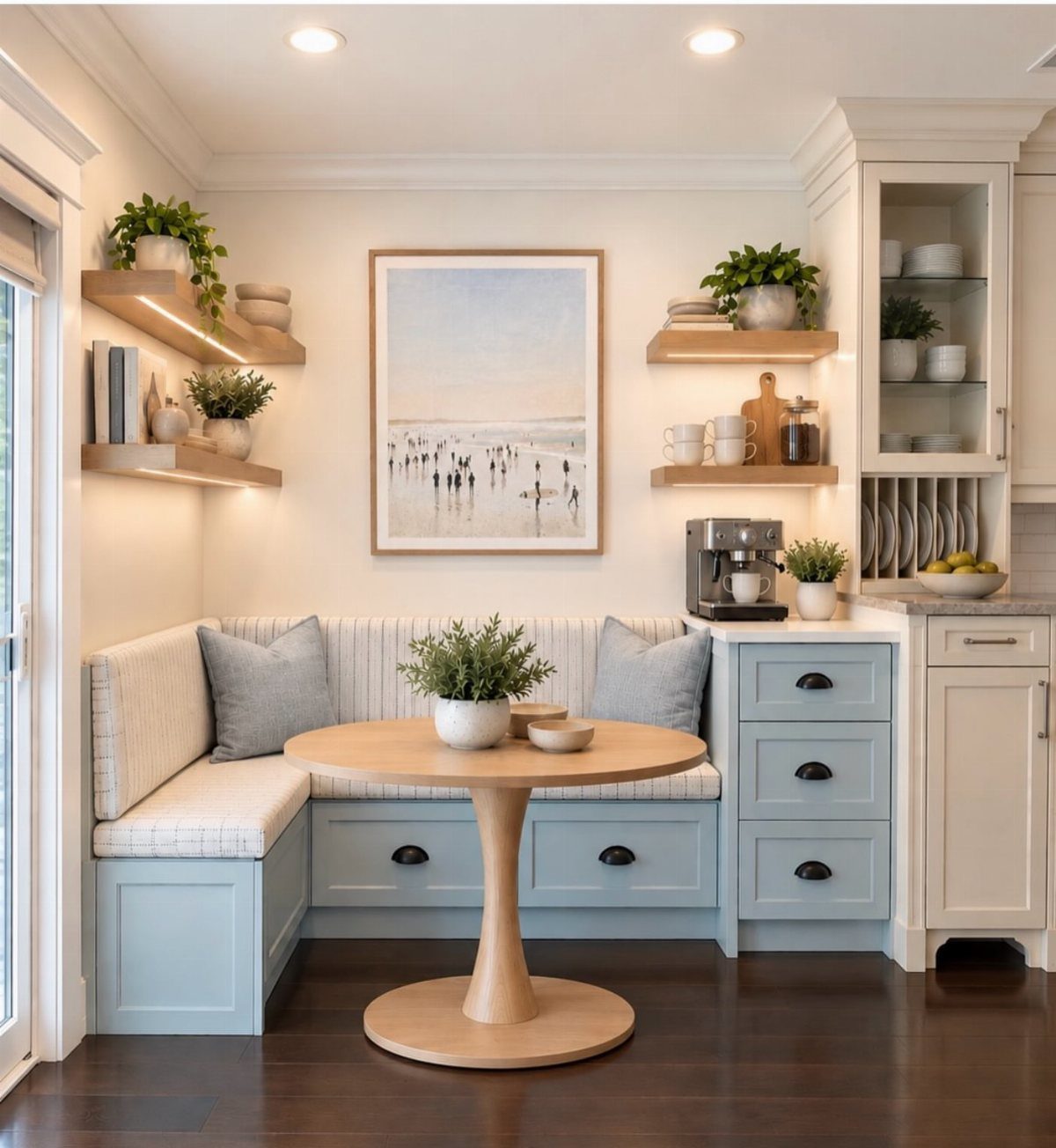 Light blue built-in breakfast nook with storage drawers and a round wooden table.