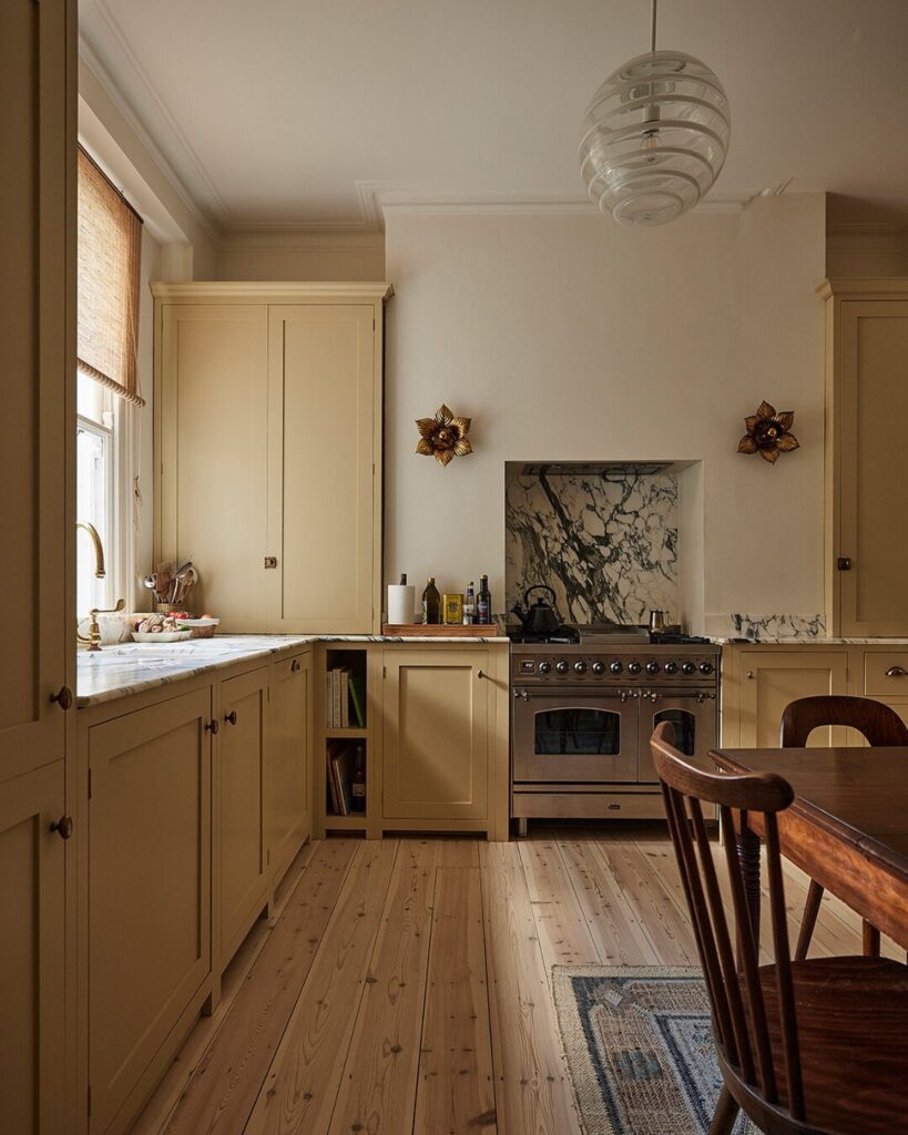 Butter yellow kitchen cabinets paired with warm white walls and light wood floors.