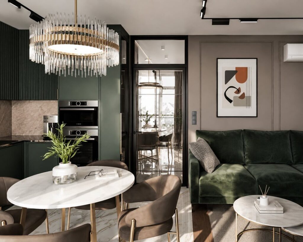 Dark green kitchen cabinets and velvet sofa in a modern open-concept living area.