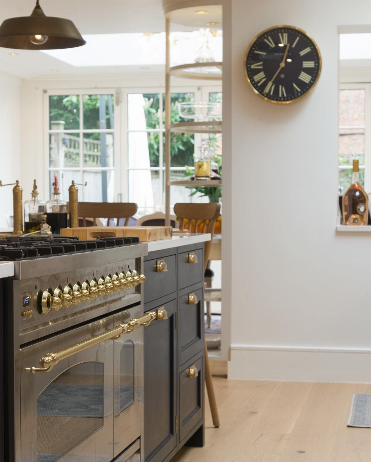 Stainless steel stove with gold knobs integrated into a dark blue kitchen island.