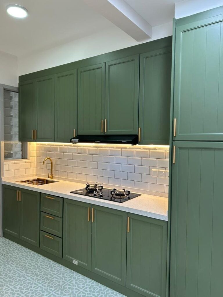 Olive green kitchen cabinets with gold hardware and white subway tile backsplash.